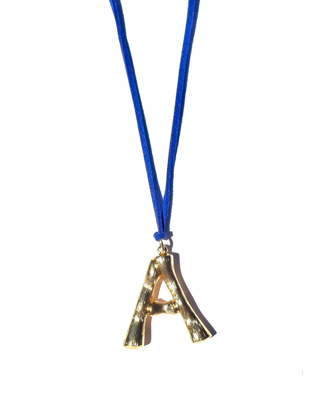 The Clásico by LAZO Collective: gold bamboo-style initial pendant on a maize yellow or azul blue suede tie cord